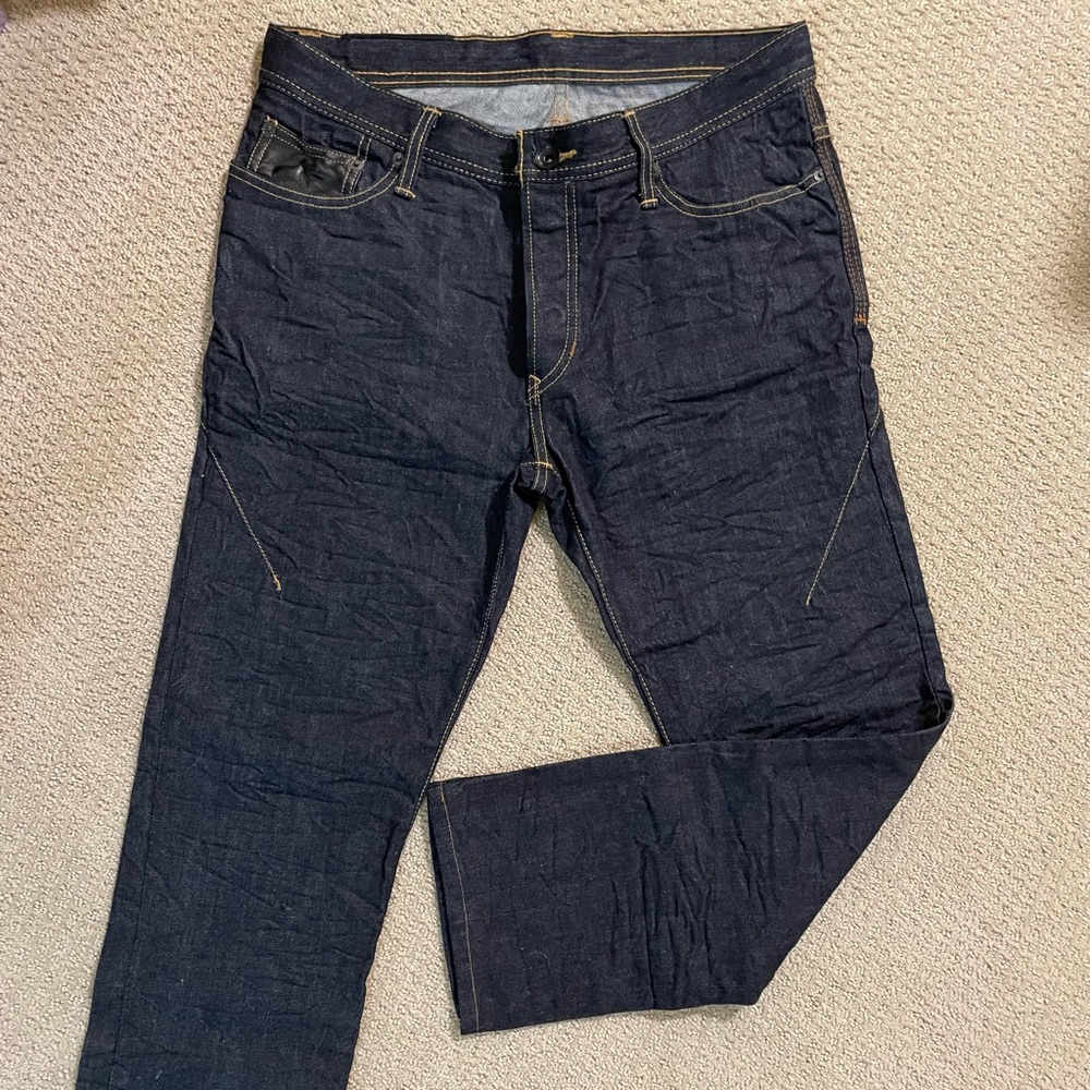 Rogue men’s dark denim jeans with button fly and leather detailing.  Size 32
